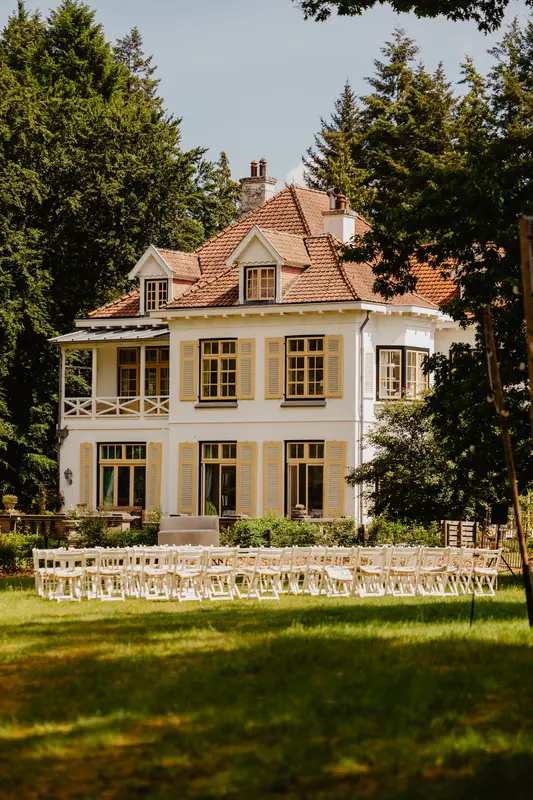 Witte villa met ceremoniestoelen op het gazon