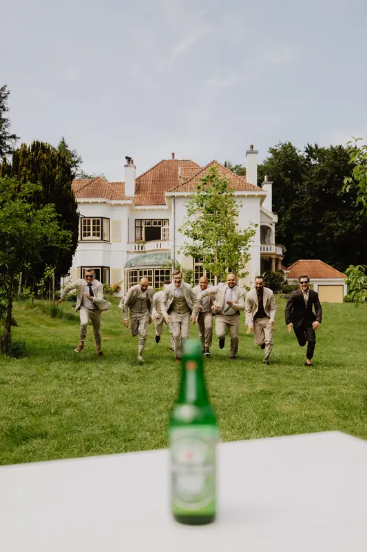 Vrienden van de bruidegom rennen over het gazon