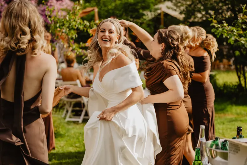 Bruid danst met vriendinnen in de tuin