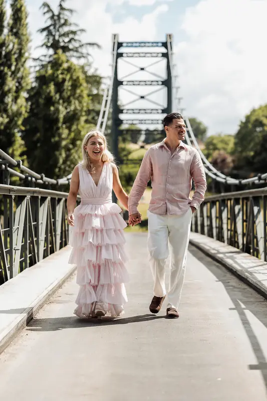 Stel loopt hand in hand over een hangbrug