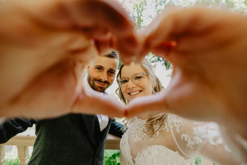Bruidspaar gefotografeerd door een hartje van handen