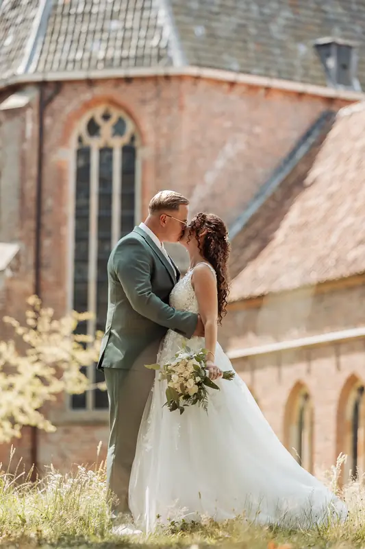 Bruidspaar kust voor een oude kerk