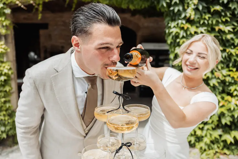 Bruidegom drinkt van de champagnetoren