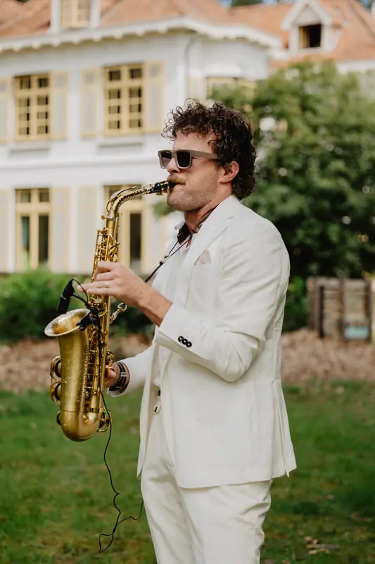 Saxofonist speelt op het gazon tijdens de receptie